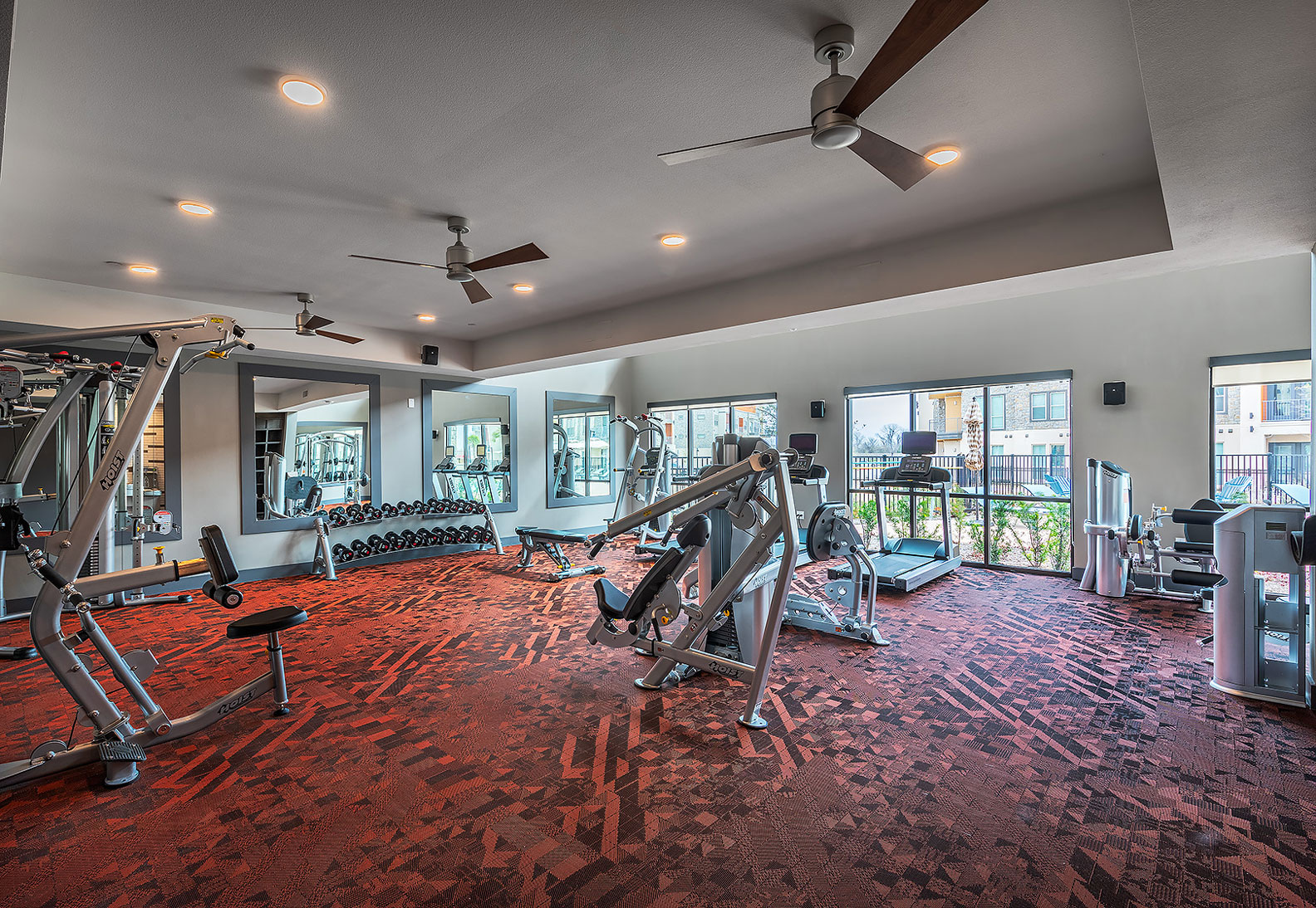 fitness center with free weights, weight machines, and ceiling fans